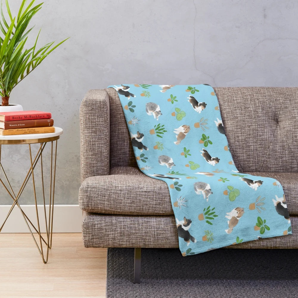 Soft and plush blue blanket featuring a Shetland sheepdog (sheltie) and a calathea house plant