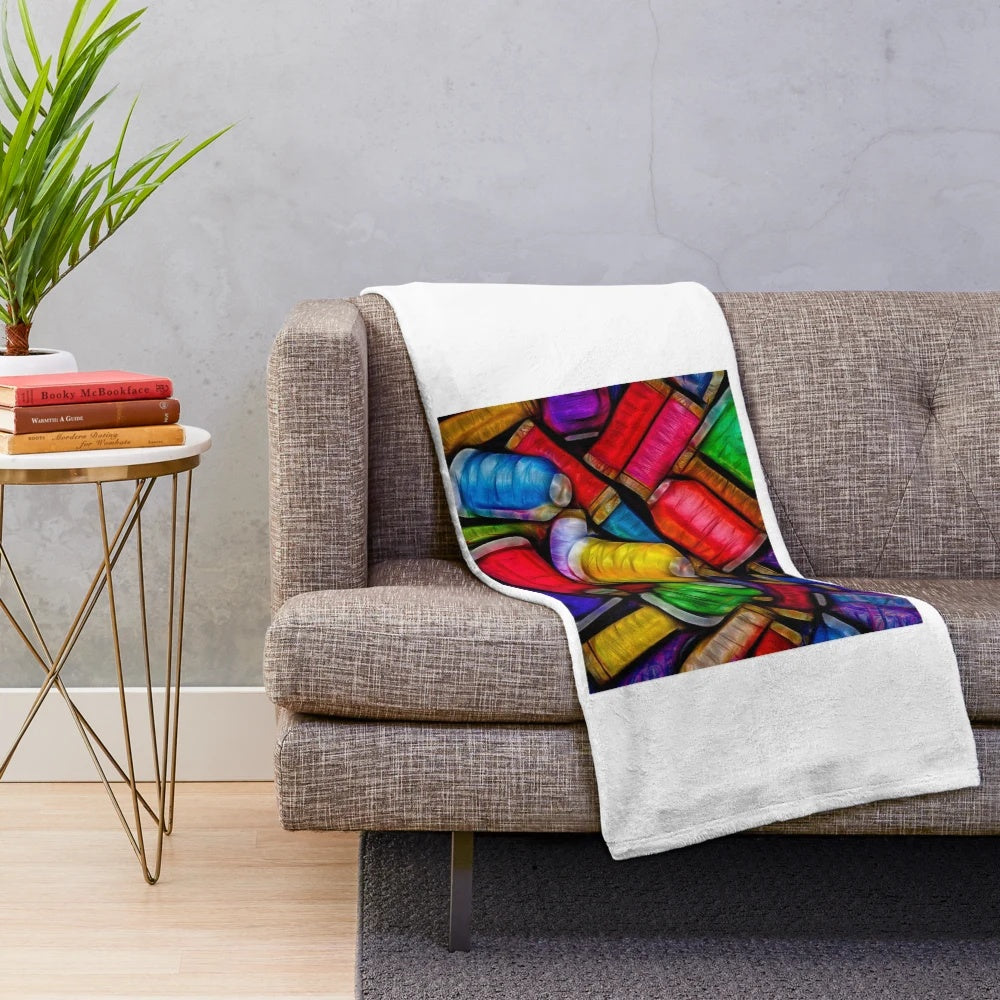 Plush blanket with intricately woven spools of thread design