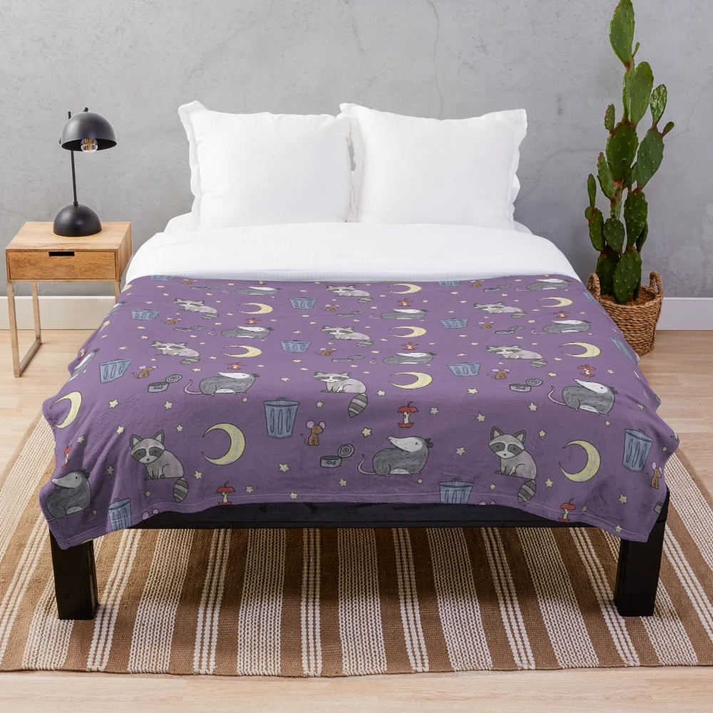 Plush blanket featuring a pattern of raccoons, opossums, and other nocturnal critters in a trash-themed design