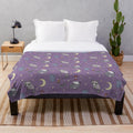 Plush blanket featuring a pattern of raccoons, opossums, and other nocturnal critters in a trash-themed design