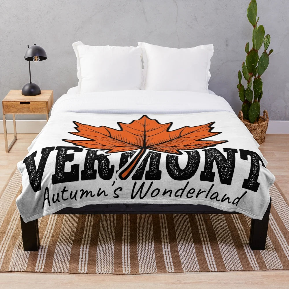 Plush blanket with illustration of vibrant orange maple leaves in an autumn landscape