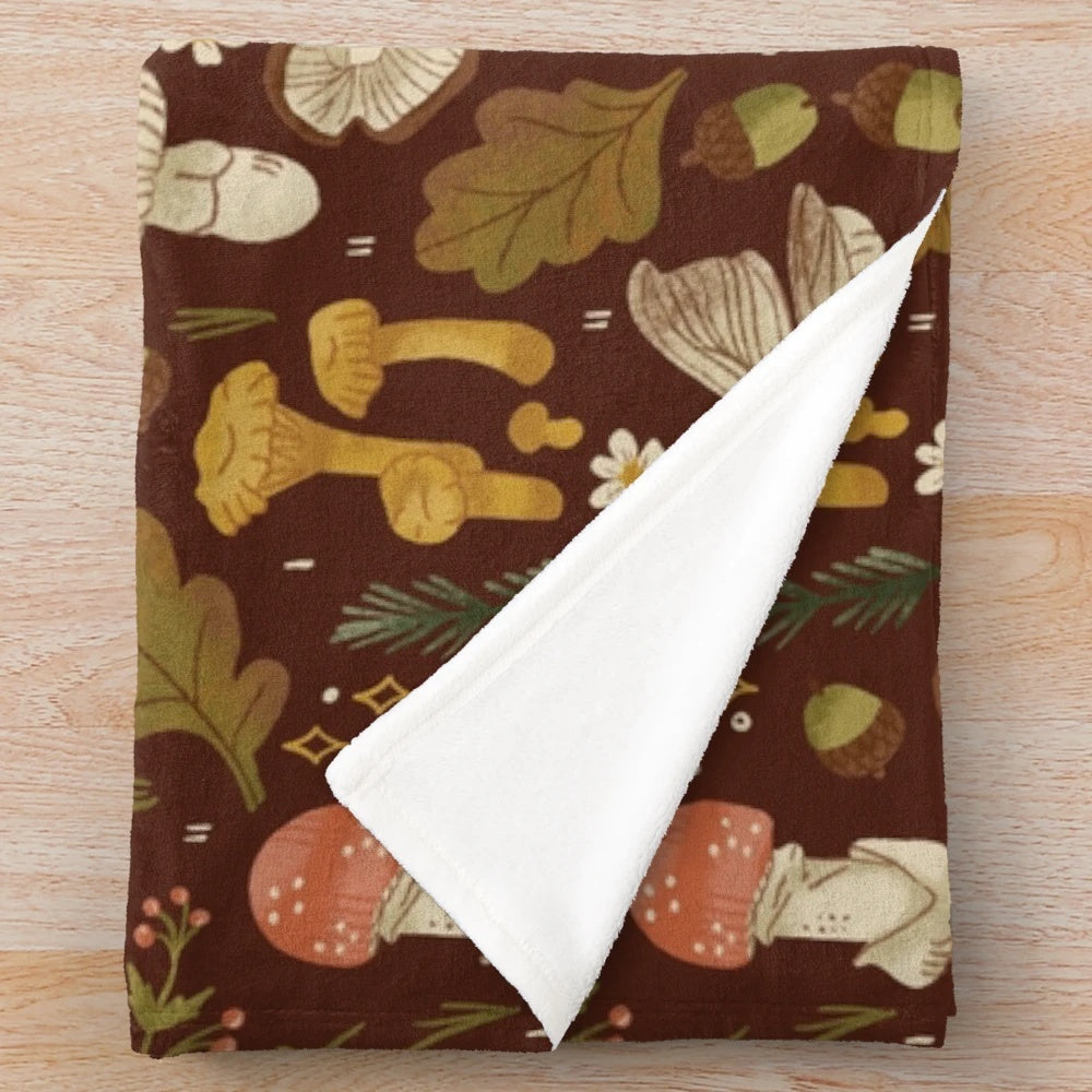 Cozy plush blanket featuring a whimsical mushroom and nature-inspired pattern
