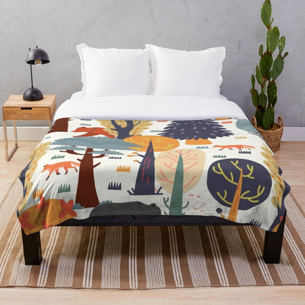 Plush blanket featuring a forest animal design with bears, foxes, and autumn colors