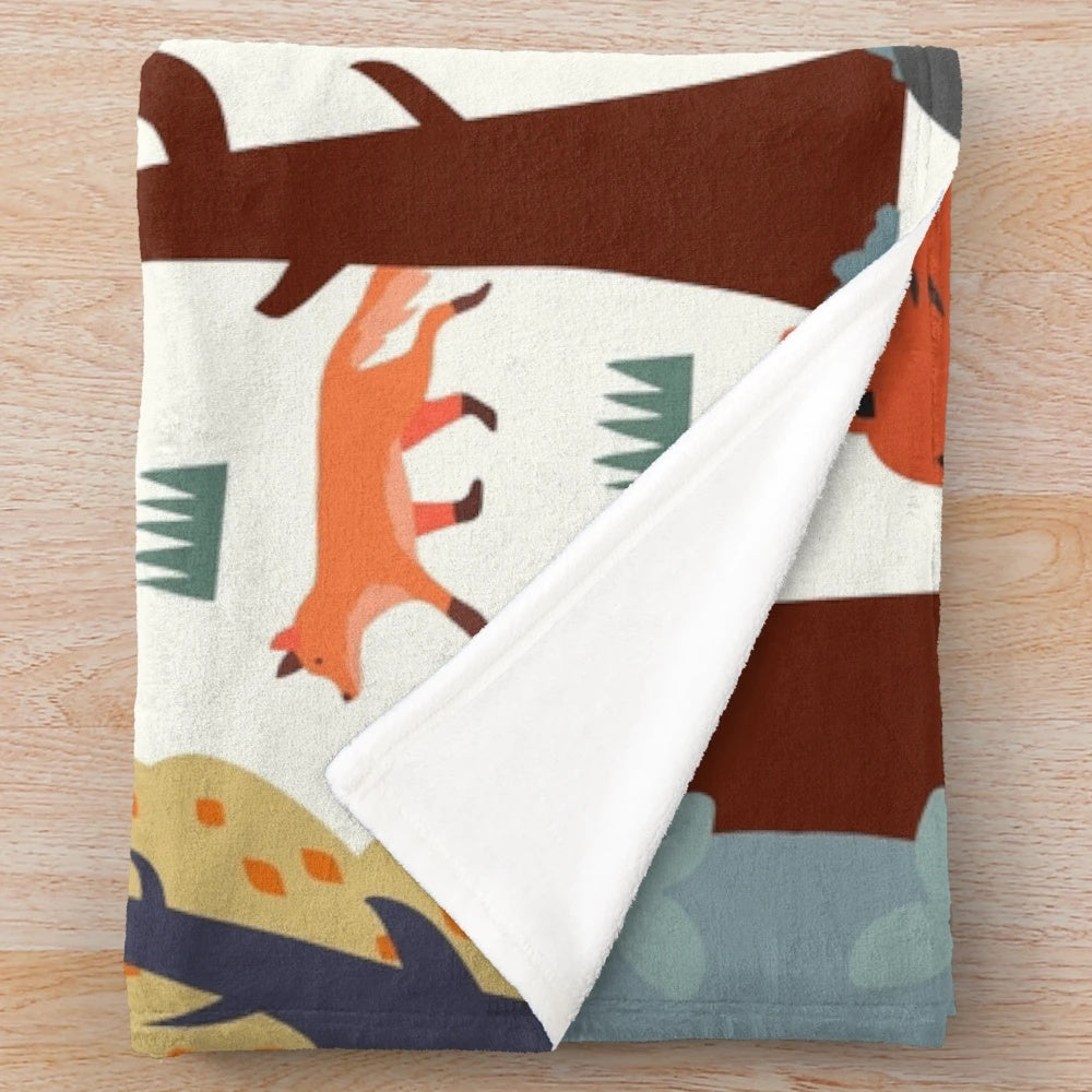 Plush blanket featuring a forest animal design with bears, foxes, and autumn colors
