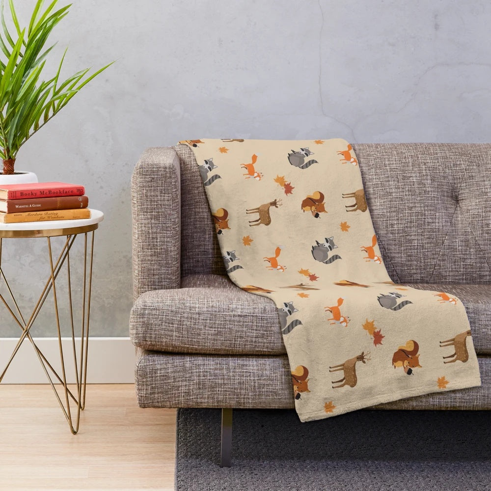 Soft plush blanket featuring woodland creatures like foxes, raccoons, and deer