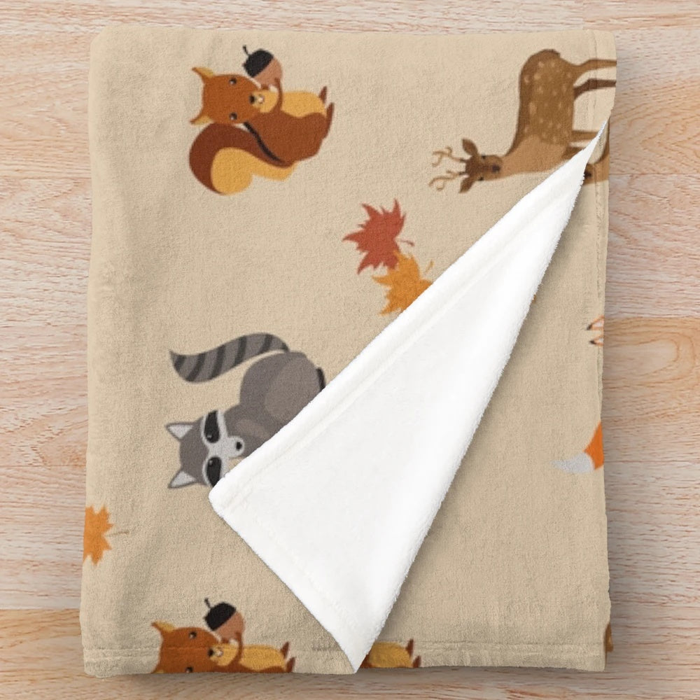 Soft plush blanket featuring woodland creatures like foxes, raccoons, and deer