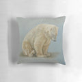 A soft and plush pillow featuring a painting of a polar bear sitting in a winter landscape by artist Carole Russell.