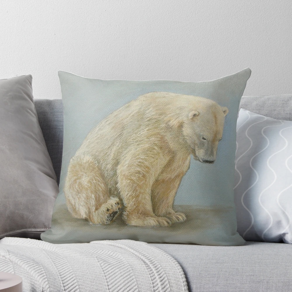 A soft and plush pillow featuring a painting of a polar bear sitting in a winter landscape by artist Carole Russell.
