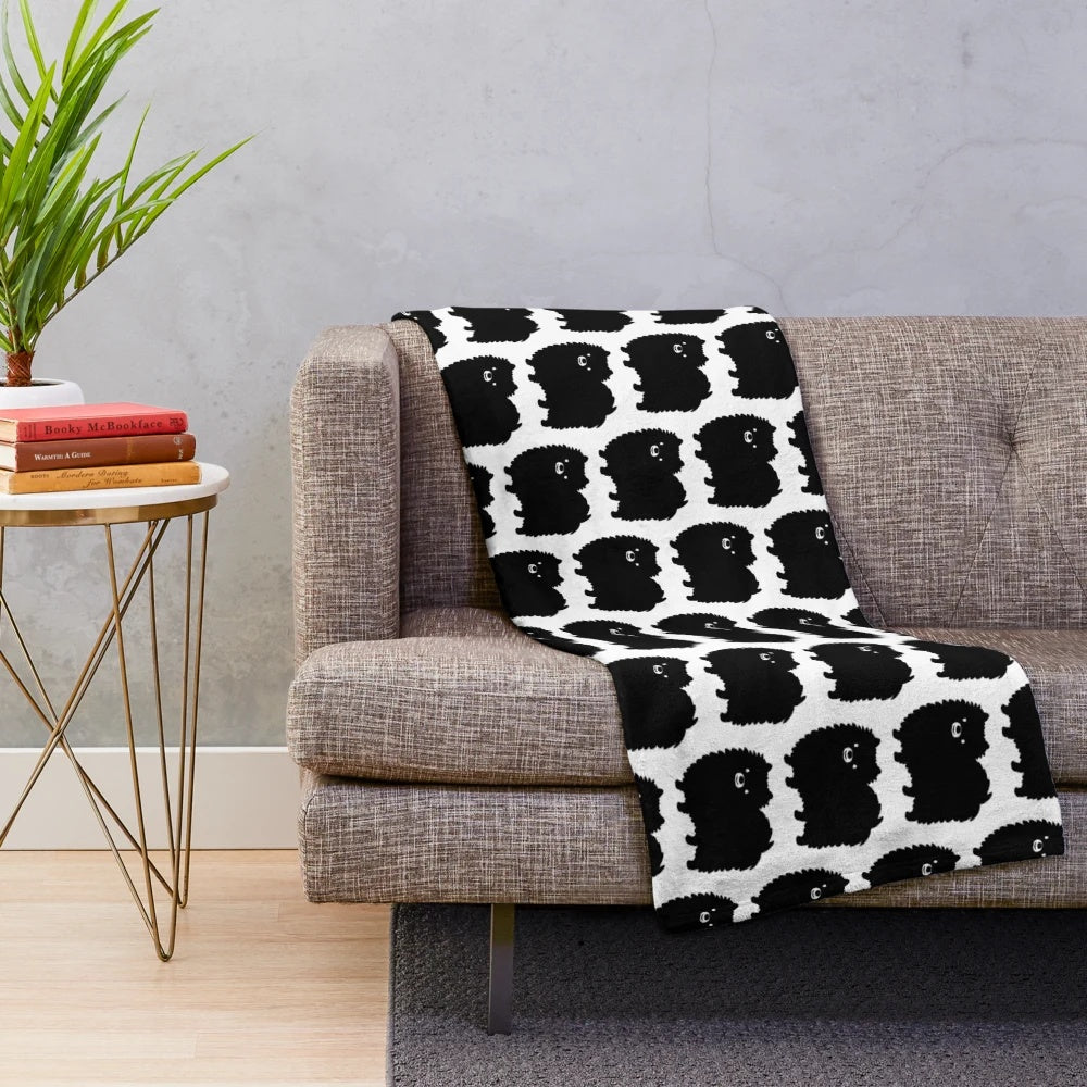 Fluffy black pomeranian dog on a soft plush blanket