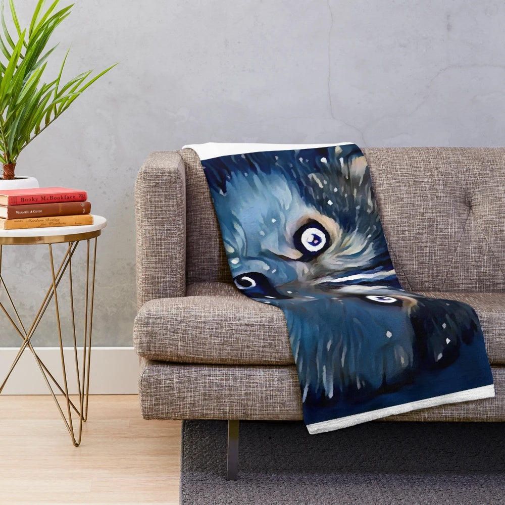 Pomsky puppy on a plush blue and white blanket