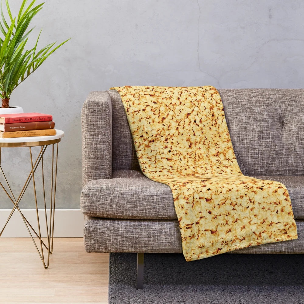 Plush blanket with a fun popcorn pattern, perfect for movie nights and cozy date nights.
