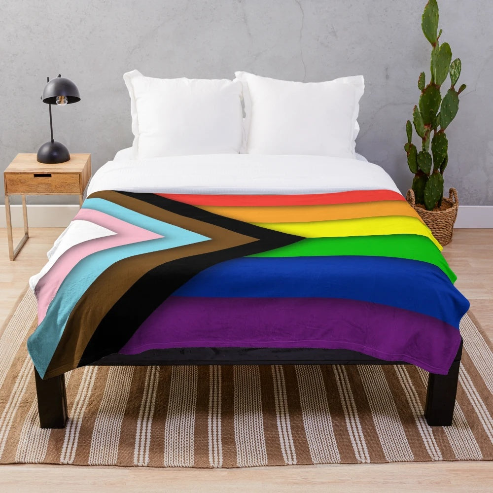 A soft and inviting plush blanket featuring the Progress Pride flag design