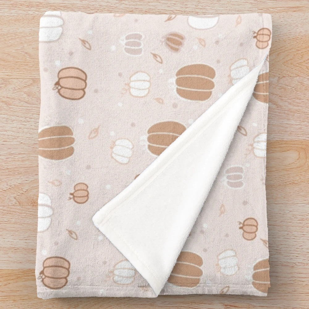 Pumpkin-themed plush blanket in beige and brown tones