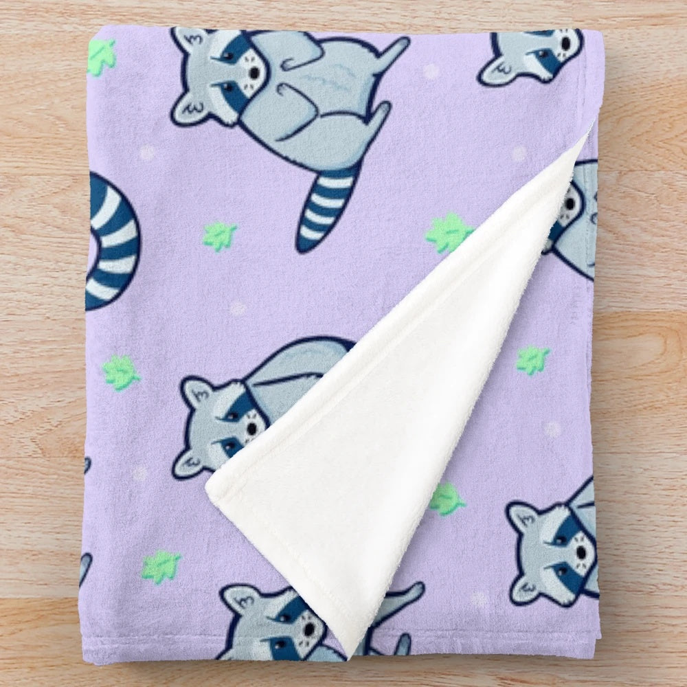 Soft and cuddly plush blanket featuring a cute raccoon pattern with leaves