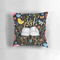 A black floral pillow with a whimsical design, perfect for bookworms and readers to enjoy.