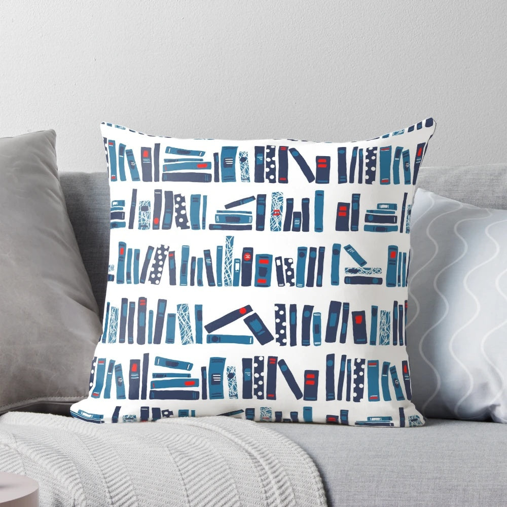 A plush reading pillow with a blue and red book pattern, perfect for cozy reading sessions.