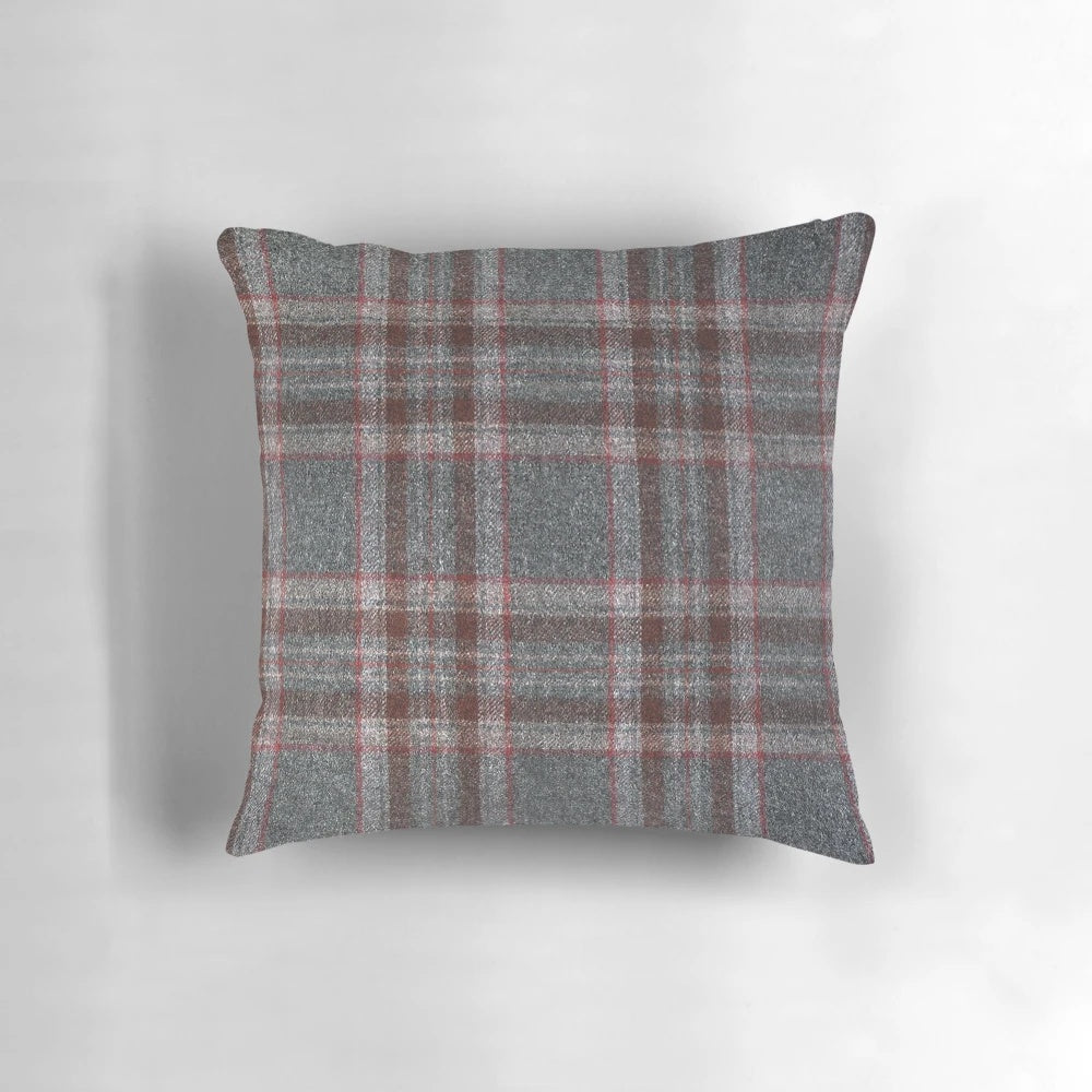 A cozy, red and grey tartan plaid throw pillow with a soft, woollen texture.
