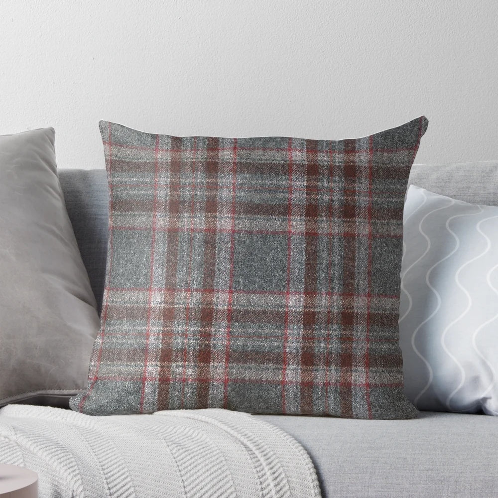 A cozy, red and grey tartan plaid throw pillow with a soft, woollen texture.