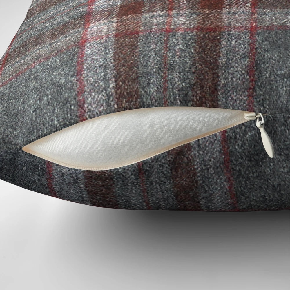 A cozy, red and grey tartan plaid throw pillow with a soft, woollen texture.