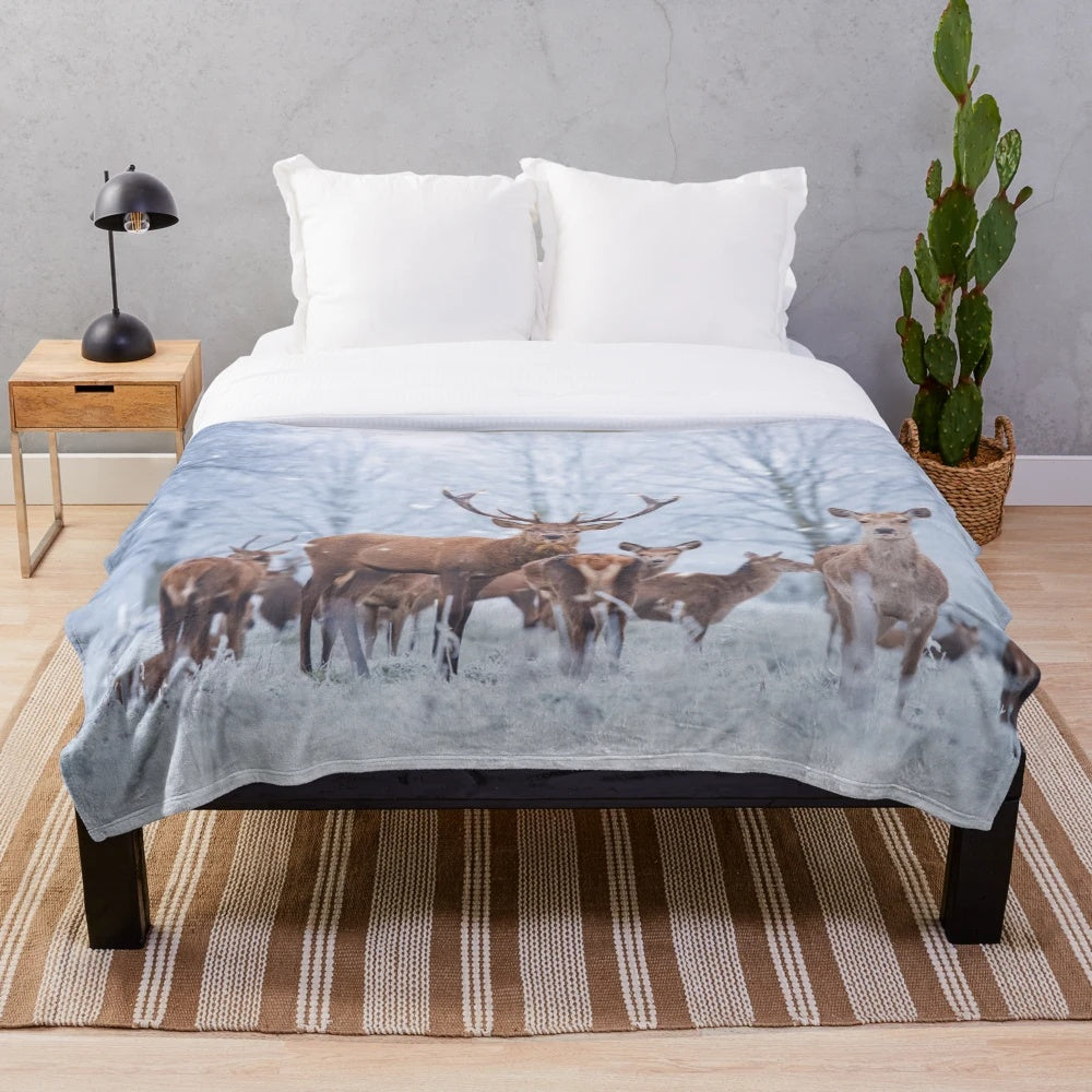 Red deer family in a snowy winter scene on a plush blanket