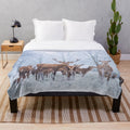 Red deer family in a snowy winter scene on a plush blanket