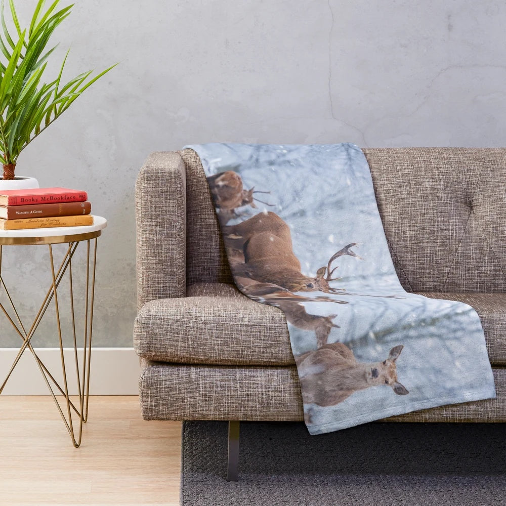 Red deer family in a snowy winter scene on a plush blanket