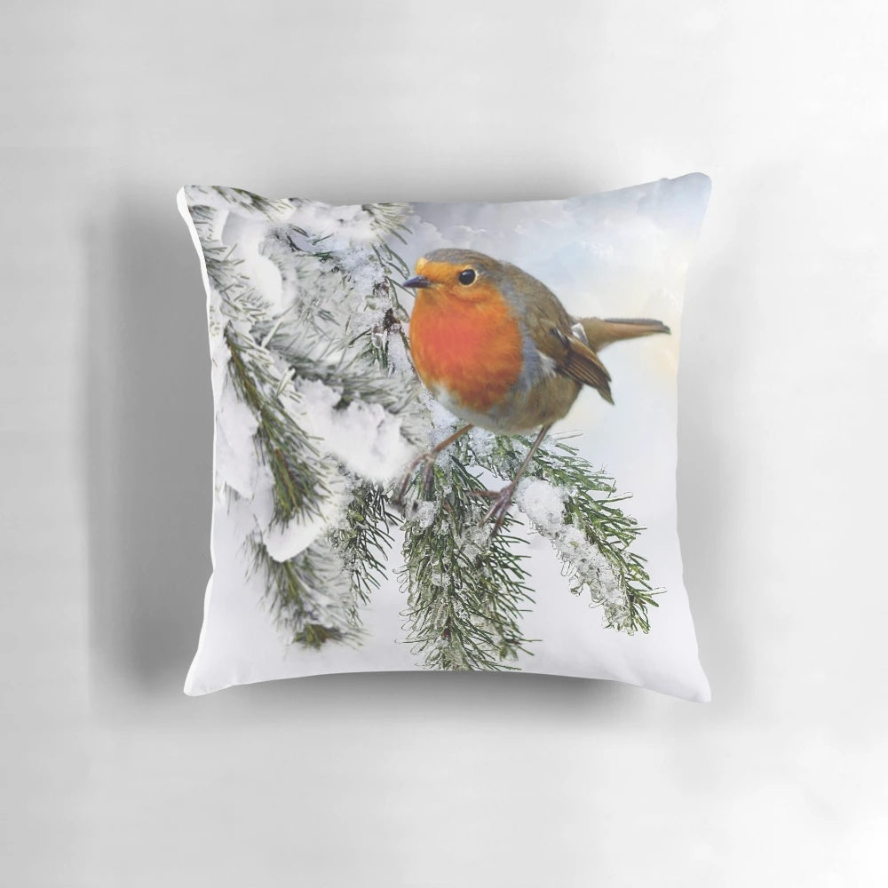 A decorative pillow featuring a beautiful robin bird perched on a snowy tree branch.