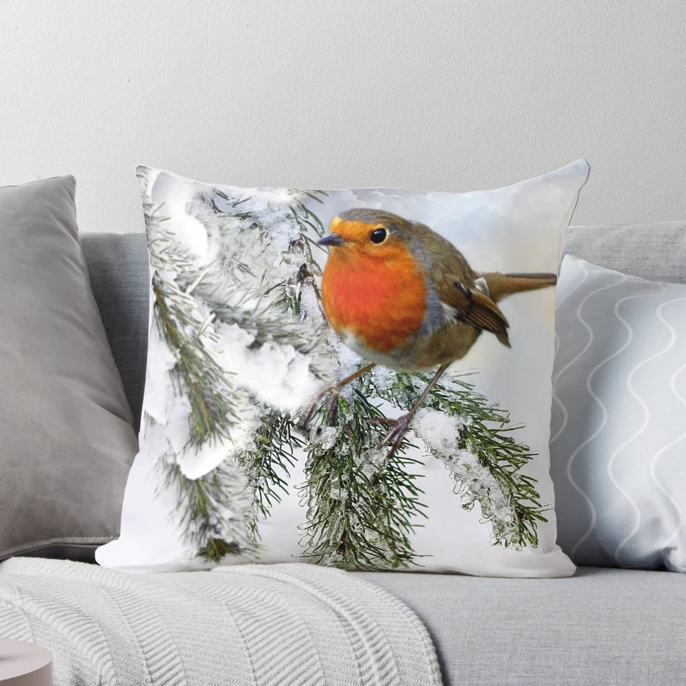 A decorative pillow featuring a beautiful robin bird perched on a snowy tree branch.