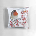 Festive pillow featuring a robin perched on snowy branches with red berries