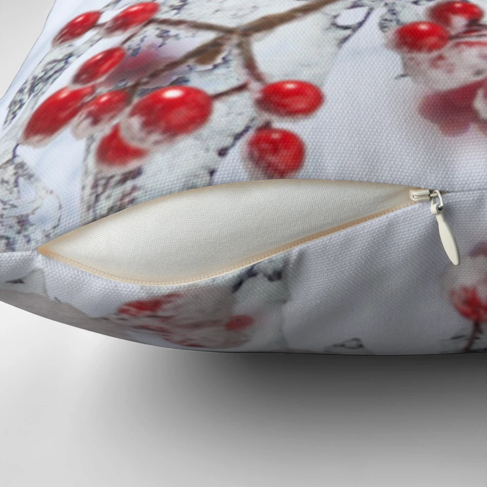 Festive pillow featuring a robin perched on snowy branches with red berries