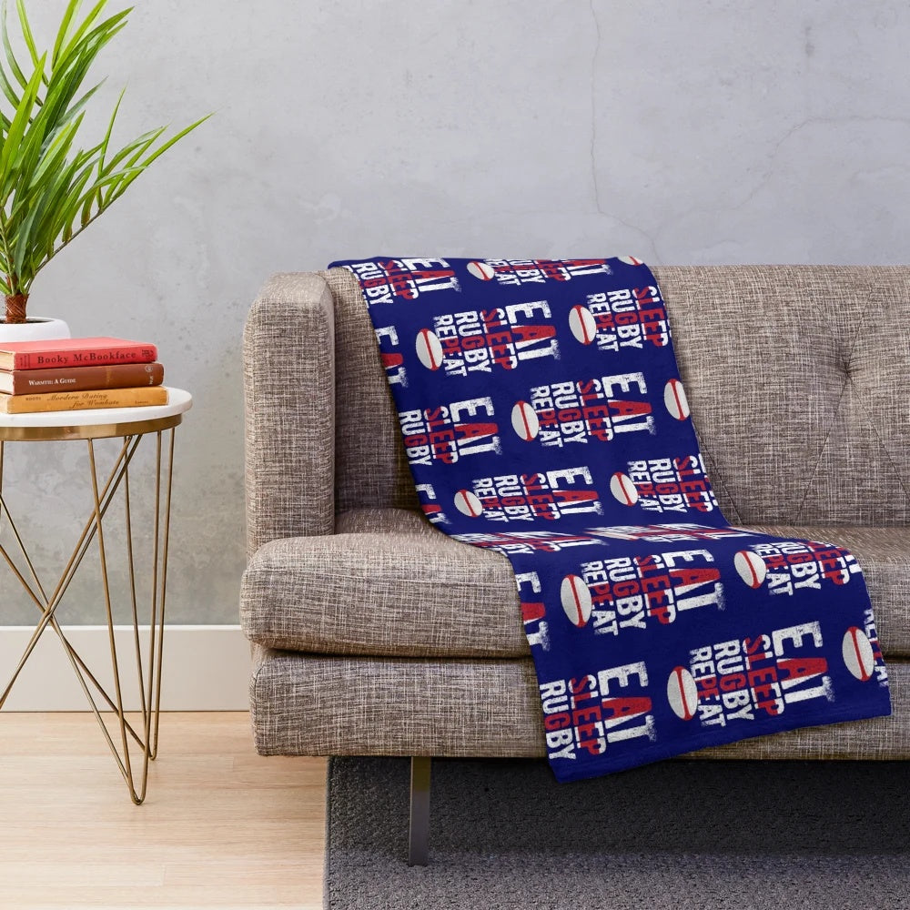 Plush blanket with "eat sleep rugby repeat" design and England rugby-inspired colors and elements