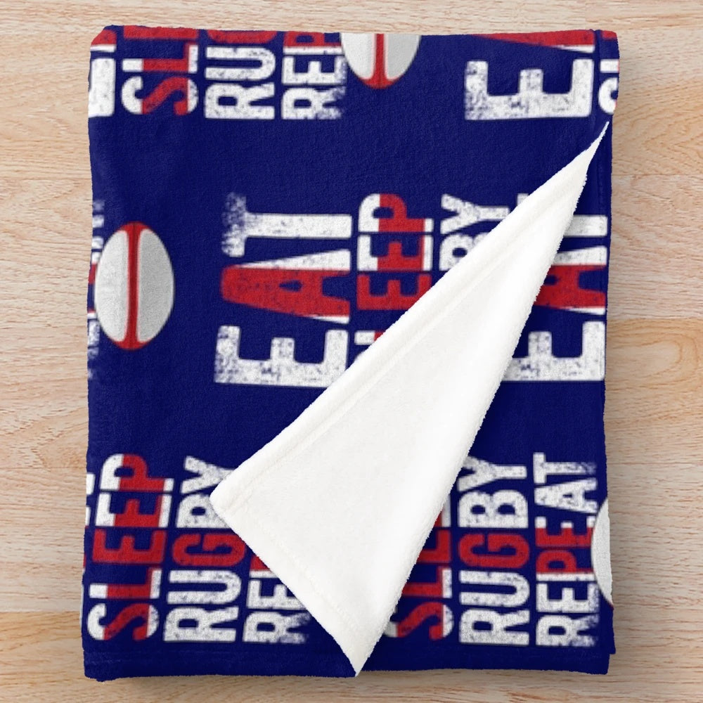 Plush blanket with "eat sleep rugby repeat" design and England rugby-inspired colors and elements