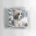 A cute Saint Bernard puppy wearing a winter hat and sitting on a snow-themed pillow.