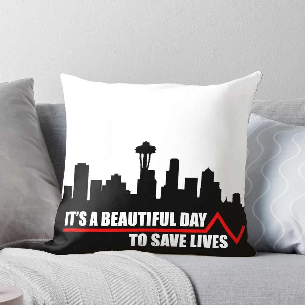 A plush pillow with the text 'Save Lives' on a plain background, inspired by the hit TV show Grey's Anatomy.
