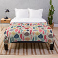Plush blanket with a scandinavian-inspired doodle leaf design in various colors