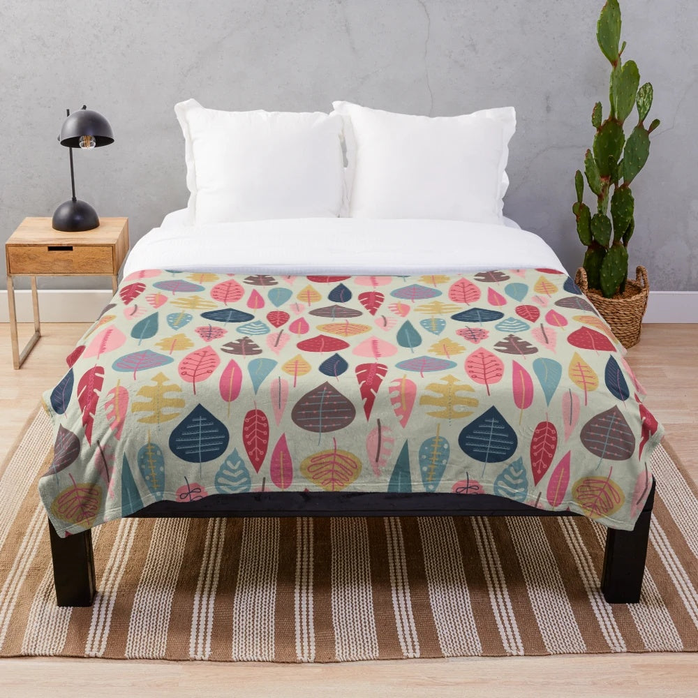 Plush blanket with a scandinavian-inspired doodle leaf design in various colors