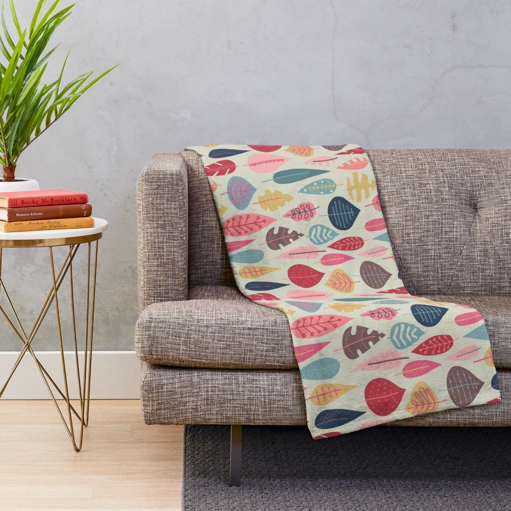 Plush blanket with a scandinavian-inspired doodle leaf design in various colors