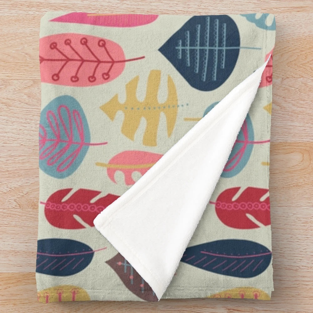 Plush blanket with a scandinavian-inspired doodle leaf design in various colors
