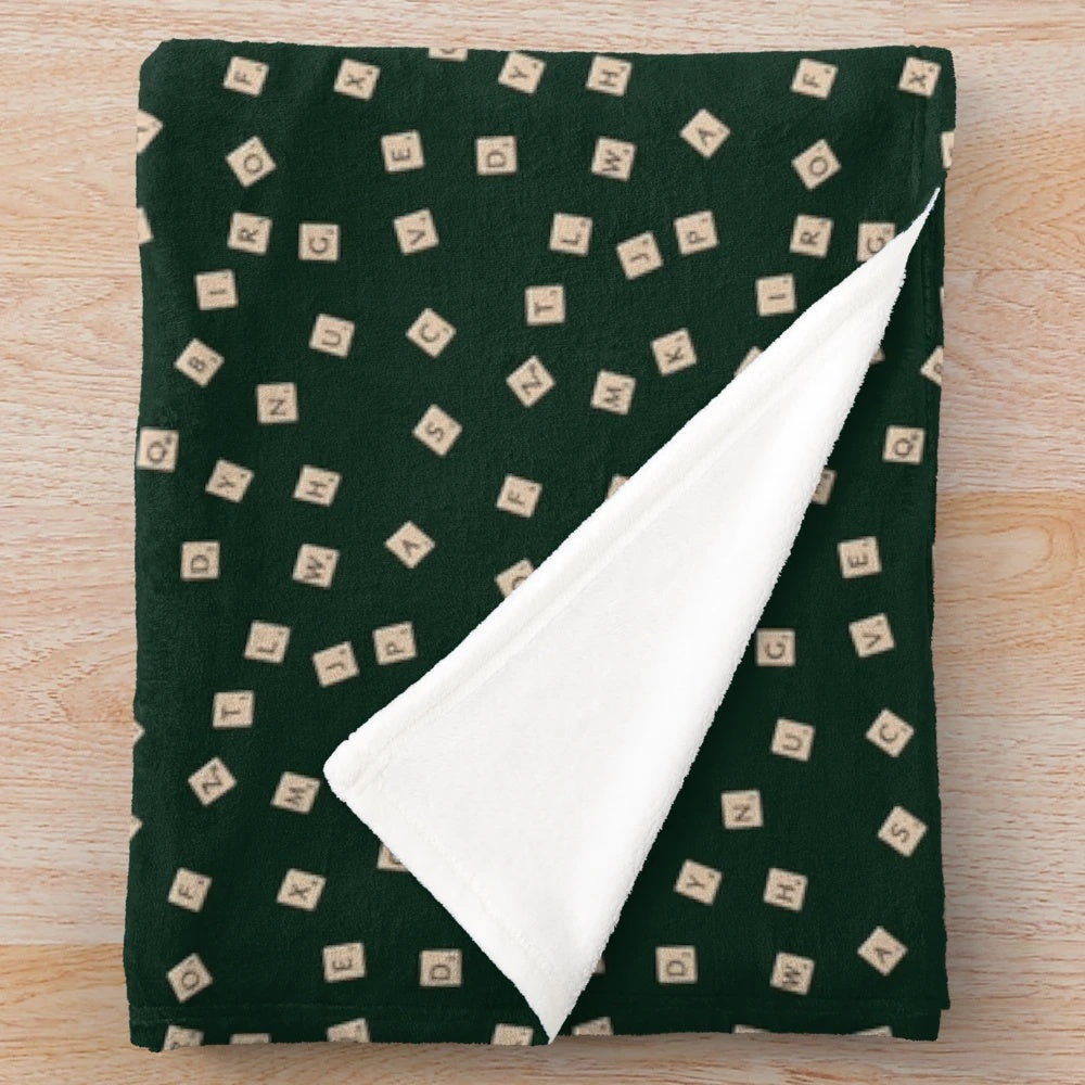 Scrabble-inspired plush blanket with letter tiles and board game design