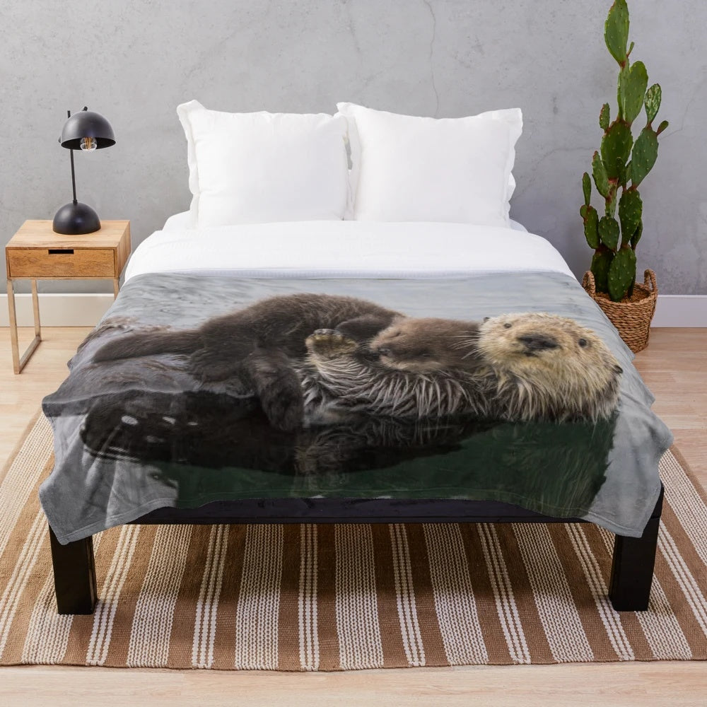 Soft plush blanket featuring a cute sea otter swimming with a baby otter