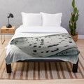 Plush blanket featuring a sleeping seal in a natural setting