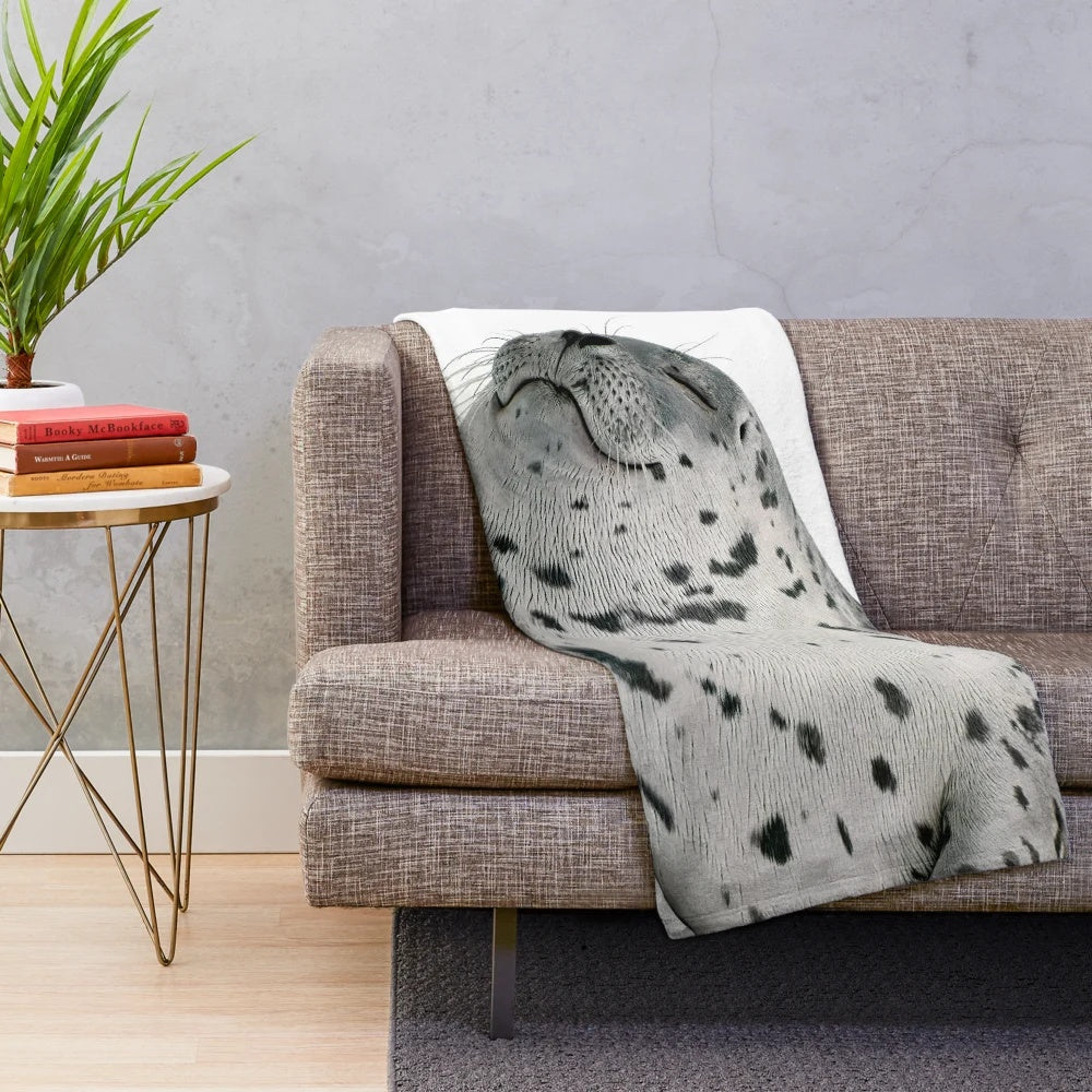 Plush blanket featuring a sleeping seal in a natural setting