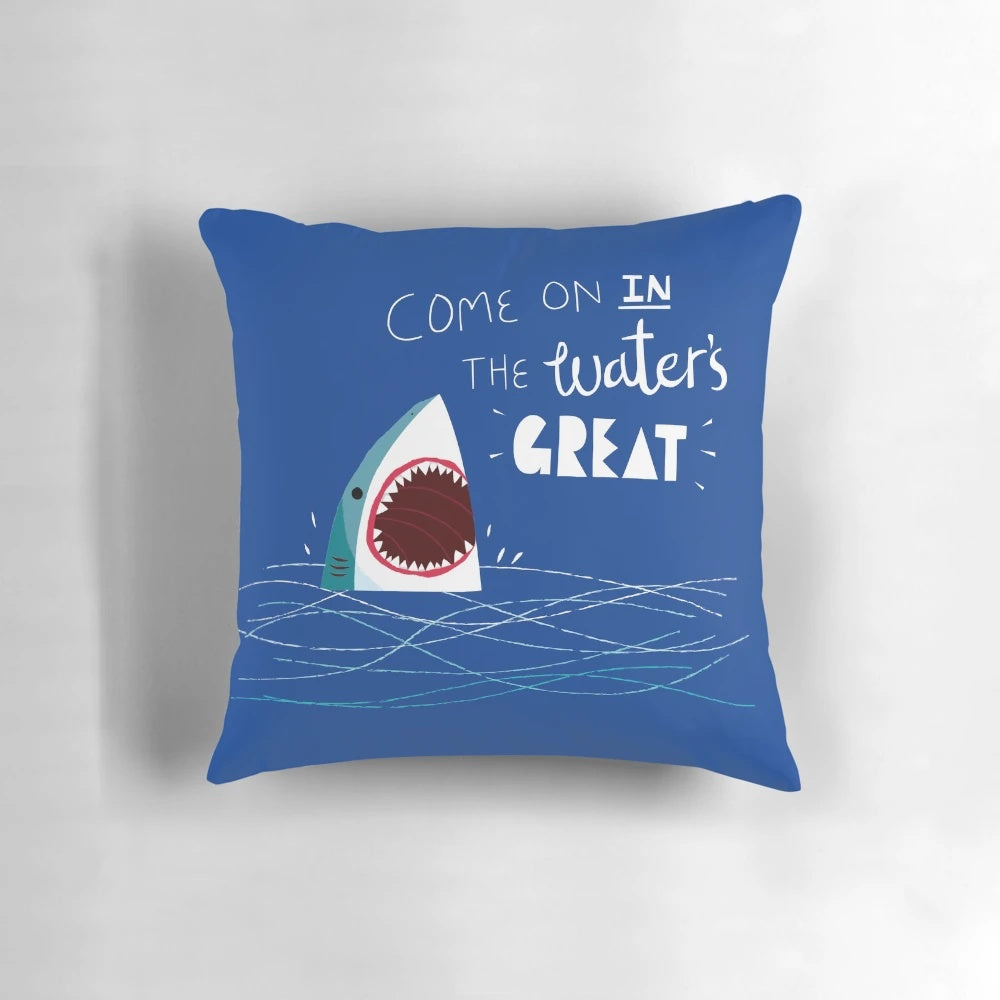 A soft, plush shark-shaped pillow with a playful typographic design, perfect for adding a touch of ocean-inspired style to any room.
