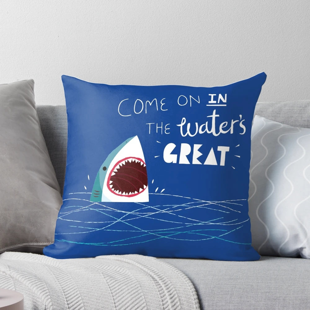 A soft, plush shark-shaped pillow with a playful typographic design, perfect for adding a touch of ocean-inspired style to any room.