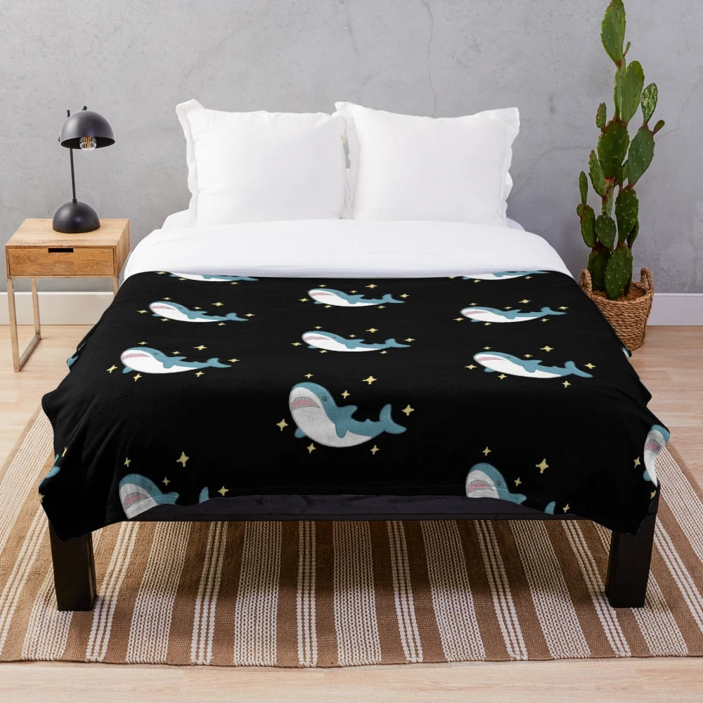 Blahaj the shark plush blanket against a black background