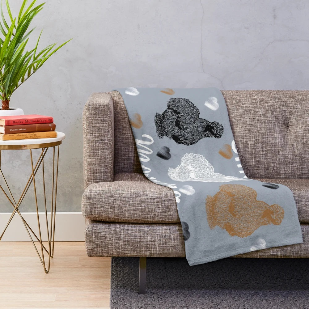Soft and fluffy silkie chicken plush blanket with heart prints in black, white, and buff colors