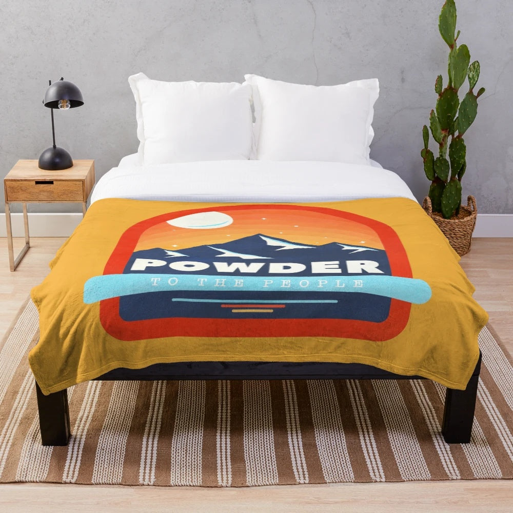 Ski-themed plush blanket with "Powder To The People" design
