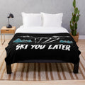 A cozy and plush blanket featuring a winter sports and snow scene design