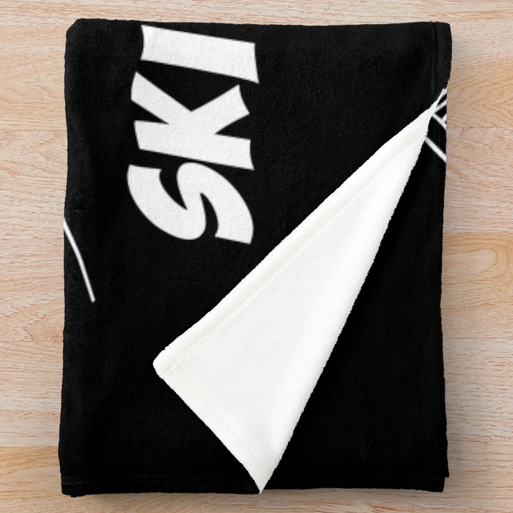 A cozy and plush blanket featuring a winter sports and snow scene design