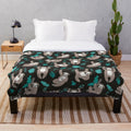 Soft and plush sloth blanket with sloths hanging on a black background